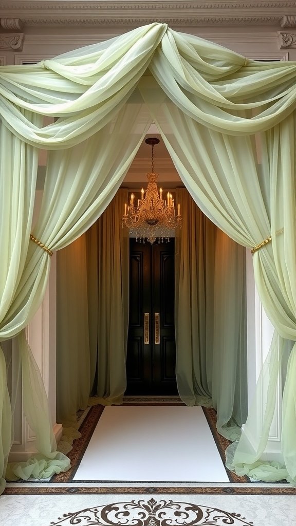 An elegant entrance adorned with sage green tulle draping and a chandelier, leading to black doors.