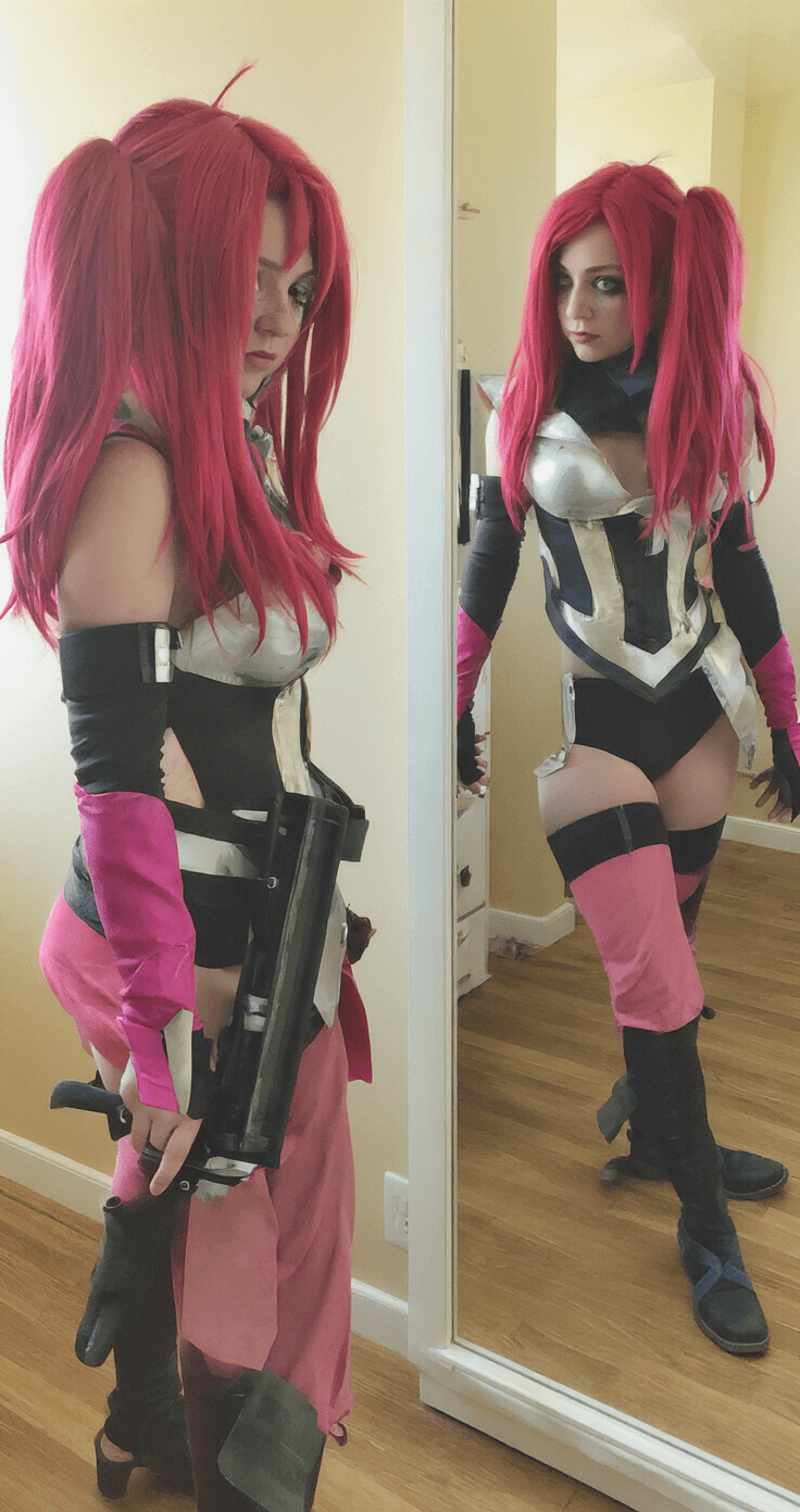 A cosplayer in full Jinx costume performs a test run, captured in warm indoor lighting with multiple angles reflected in a mirror. The image showcases natural movement and the fabric's flow, highlighting the costume's intricate design and how the pieces complement each other in a documentary-style candid shot.