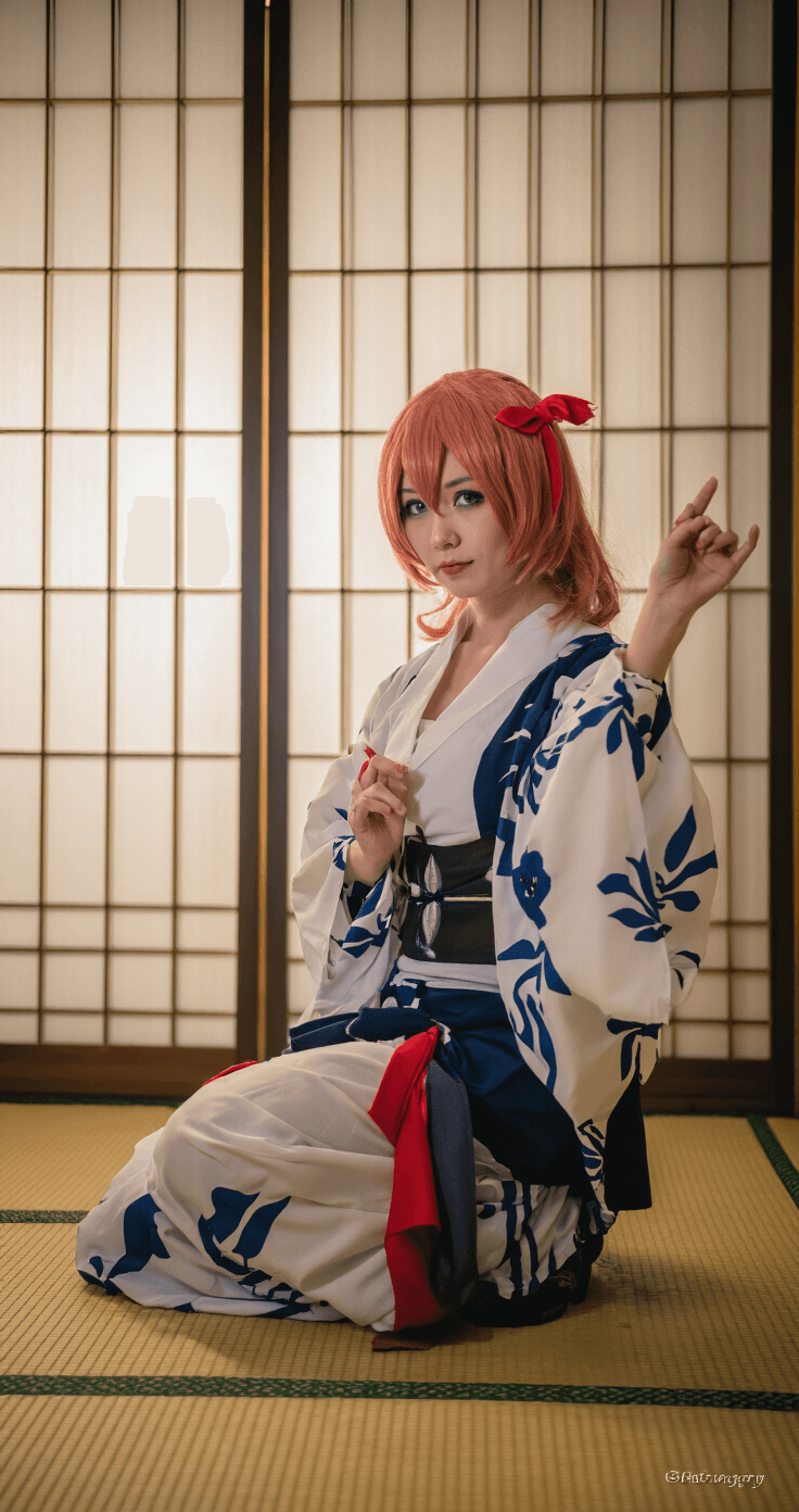 A model in full Sukuna cosplay poses in a traditional Japanese room with tatami mats and shoji screens, showcasing intricate costume details, captured with an 85mm lens at f/2.0 for soft background blur.