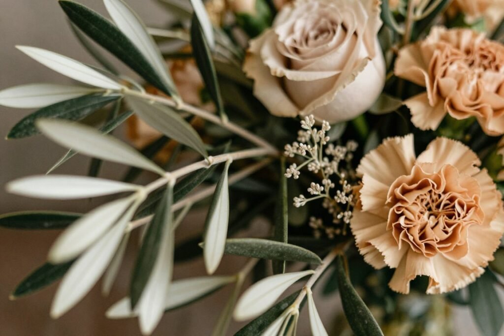 Close-up of mixed greenery and earth-tone flowers showing texture variety