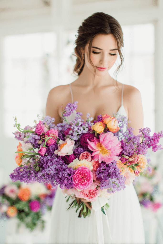 Purple wedding reception with bright lilac flowers, elegant table settings, and airy decorative elements creating a romantic and joyful atmosphere